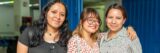 Three friends posing happily together indoors, showcasing friendship and joy.